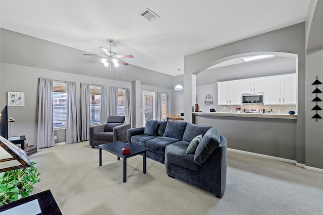 carpeted living room with lofted ceiling and ceiling fan