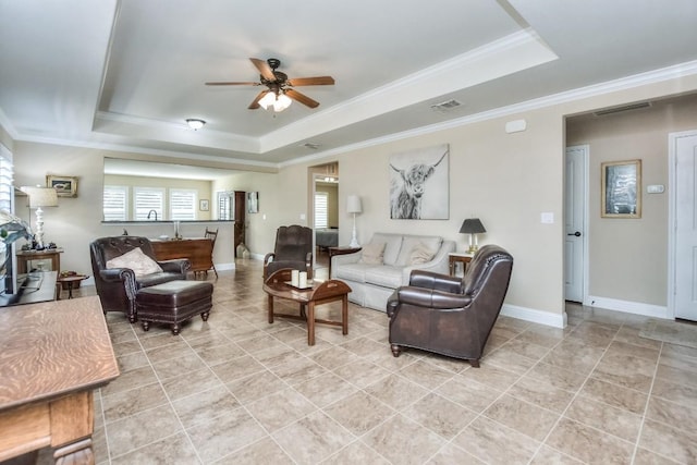 tiled living room featuring a raised ceiling, crown molding, and ceiling fan