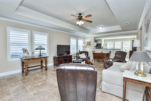 living room featuring ornamental molding, a raised ceiling, and ceiling fan