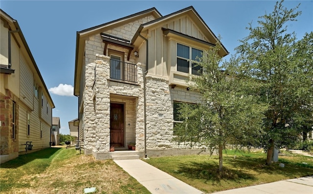 view of front of home with a balcony and a front yard