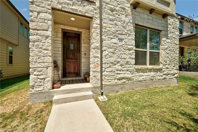 property entrance featuring a lawn