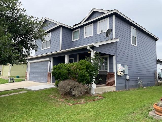 view of front of house with a garage, a front lawn, and covered porch