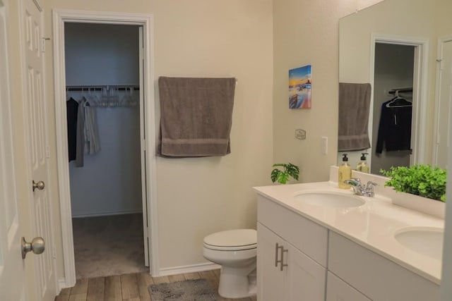 bathroom with hardwood / wood-style flooring, vanity, and toilet