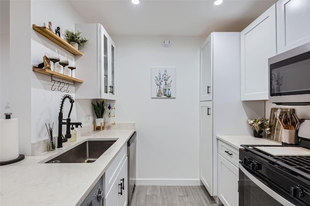 1200 E 52nd St Unit 108, Austin, TX 78723 - kitchen with stainless steel appliances, open shelves, recessed lighting, white cabinets, and light stone countertops