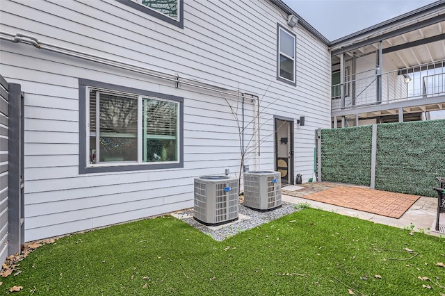 back of property featuring cooling unit, a lawn, and a patio