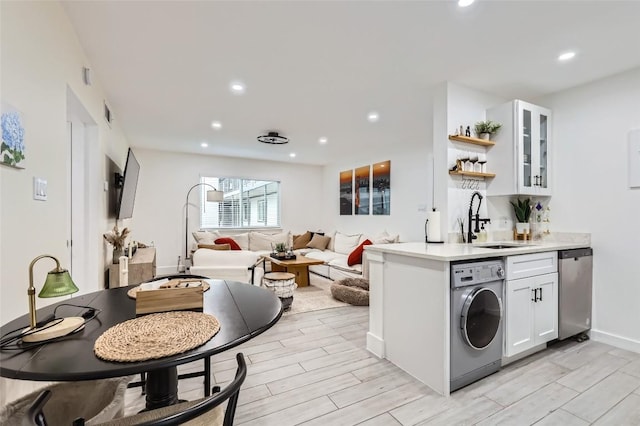 1200 E 52nd St Unit 108, Austin, TX 78723 - kitchen with washer / clothes dryer, dishwasher, white cabinetry, wood tiled floors, and recessed lighting