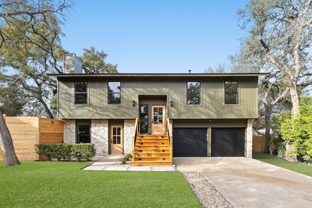 bi-level home with a garage and a front lawn