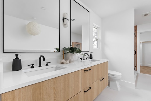 bathroom featuring vanity, a shower with shower door, and toilet