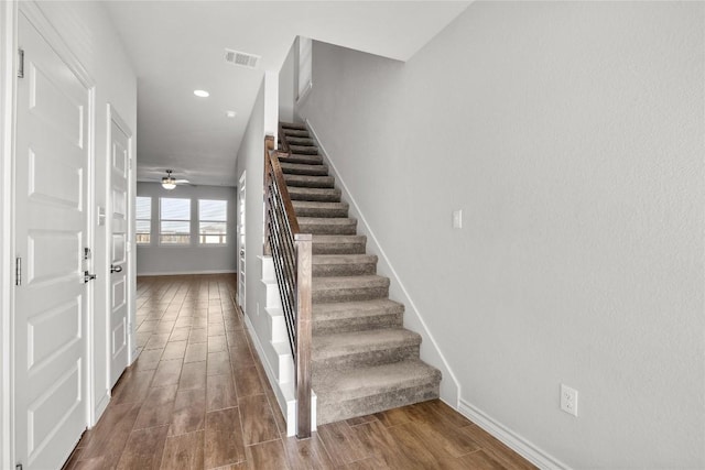 stairs featuring wood tiled floor, visible vents, and baseboards