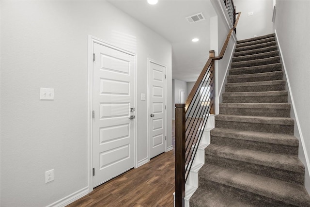 stairway featuring baseboards, wood finished floors, visible vents, and recessed lighting