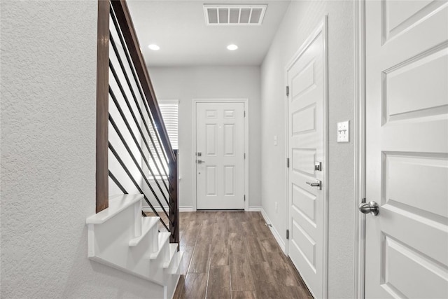 foyer entrance featuring recessed lighting, dark wood-type flooring, visible vents, baseboards, and stairs