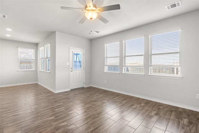 foyer entrance featuring ceiling fan, wood finished floors, visible vents, and baseboards