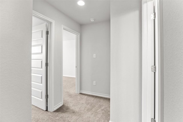 corridor featuring carpet floors and baseboards