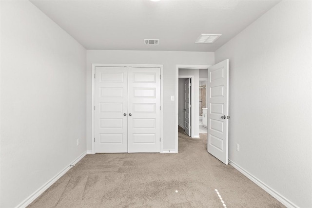 unfurnished bedroom with carpet, a closet, visible vents, and baseboards