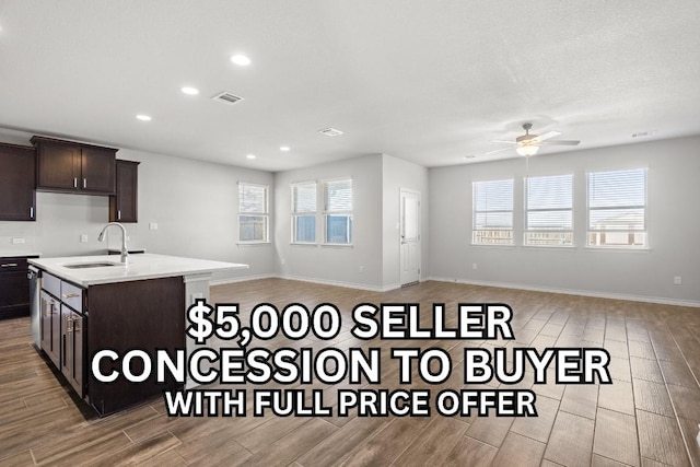 798 Eves Necklace Dr, Buda, TX 78610 - kitchen with a sink, wood tiled floors, a ceiling fan, open floor plan, and dark brown cabinetry