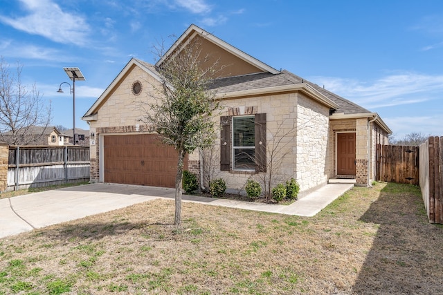 view of front facade with driveway, stone siding, fence, roof with shingles, and a garage