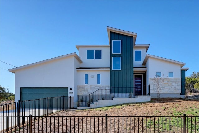 4067 Outpost Trce, Lago Vista, TX 78645 - modern home featuring stone siding, stucco siding, an attached garage, driveway, and board and batten siding