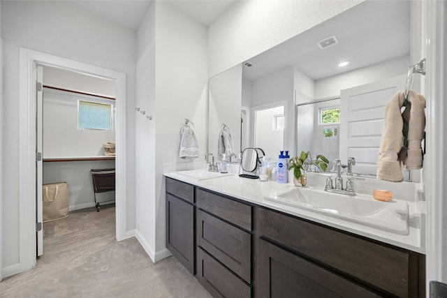 bathroom with a shower with door, vanity, and a wealth of natural light