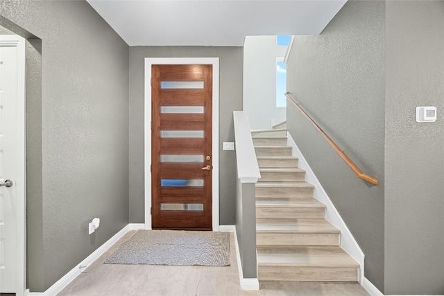 4067 Outpost Trce, Lago Vista, TX 78645 - entrance foyer with a textured wall, stairs, and wood finished floors