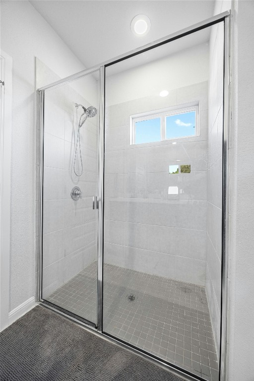 bathroom featuring a shower with door