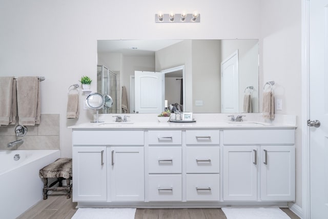 bathroom with wood-type flooring, separate shower and tub, and vanity