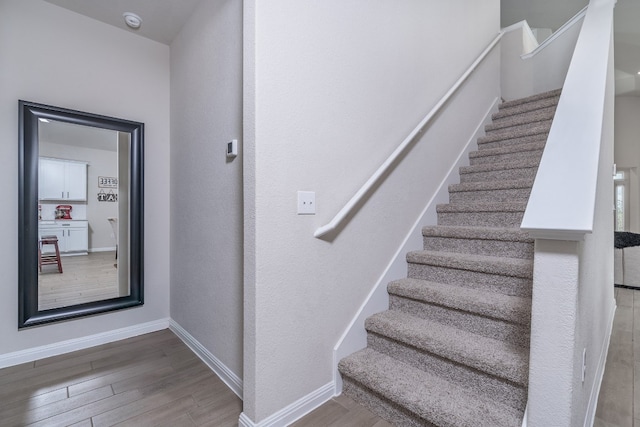 staircase with hardwood / wood-style flooring