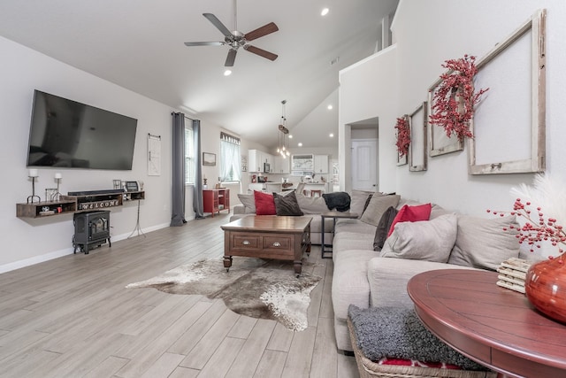 living room featuring ceiling fan, high vaulted ceiling, and light wood-type flooring