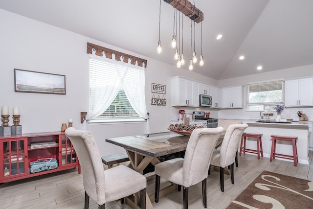 dining area featuring vaulted ceiling and light hardwood / wood-style floors