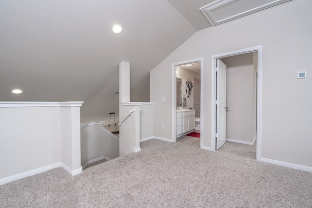 additional living space featuring vaulted ceiling and light carpet