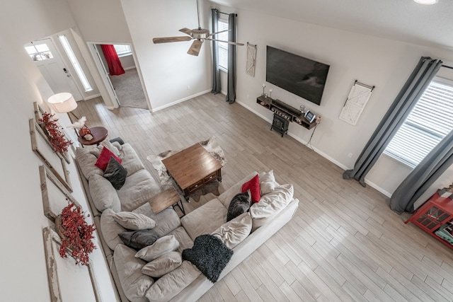 living room featuring ceiling fan, light hardwood / wood-style floors, and a healthy amount of sunlight