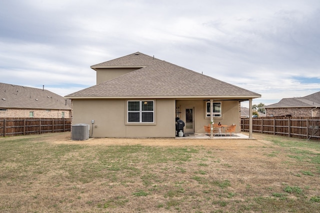 rear view of property with a patio area, central AC, and a lawn