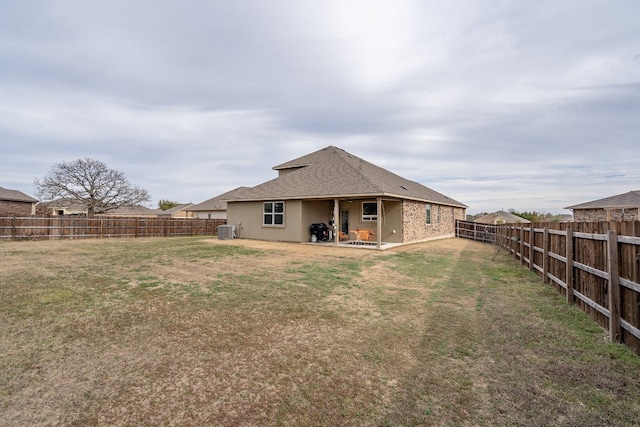 back of house with cooling unit, a yard, and a patio area