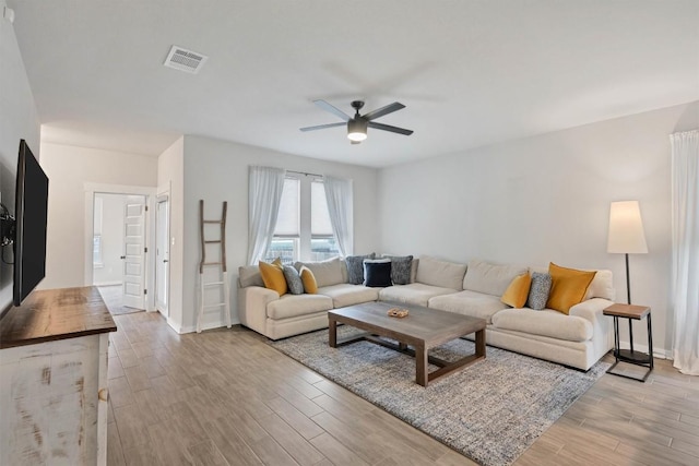 living room featuring ceiling fan and light hardwood / wood-style floors