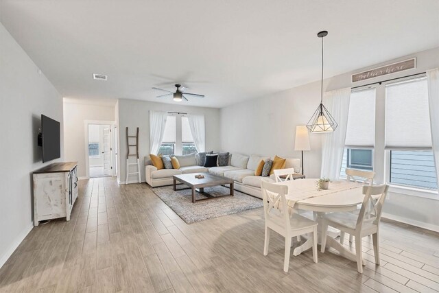 living room with ceiling fan and light wood-type flooring