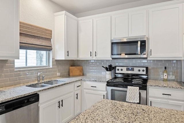 kitchen with tasteful backsplash, stainless steel appliances, sink, and white cabinets