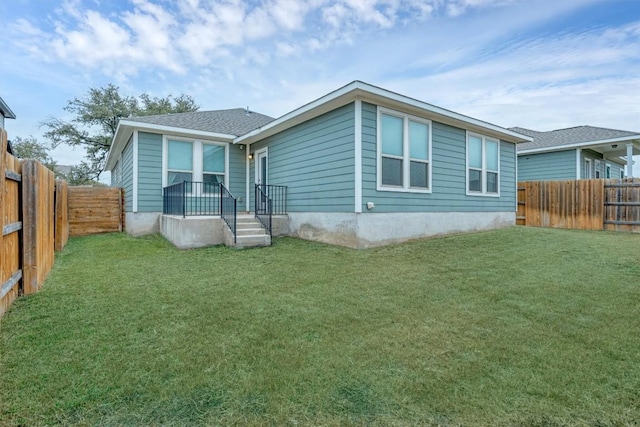 rear view of property featuring a lawn