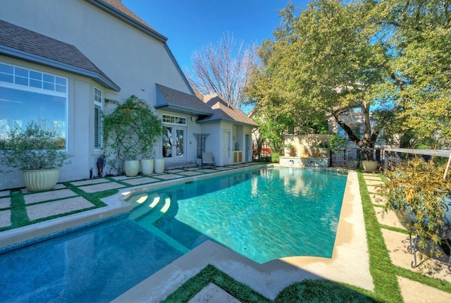 view of swimming pool with french doors