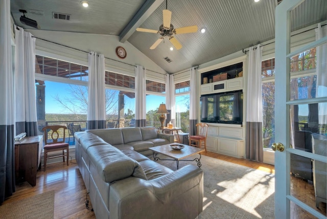 living room featuring ceiling fan, lofted ceiling with beams, light hardwood / wood-style floors, and a healthy amount of sunlight