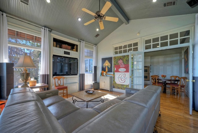 living room featuring beam ceiling, wood-type flooring, high vaulted ceiling, and a healthy amount of sunlight