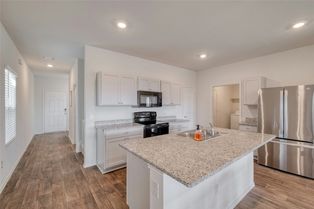 kitchen featuring white cabinetry, a kitchen island with sink, sink, and black appliances