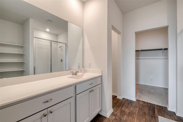 bathroom featuring hardwood / wood-style flooring, vanity, and an enclosed shower