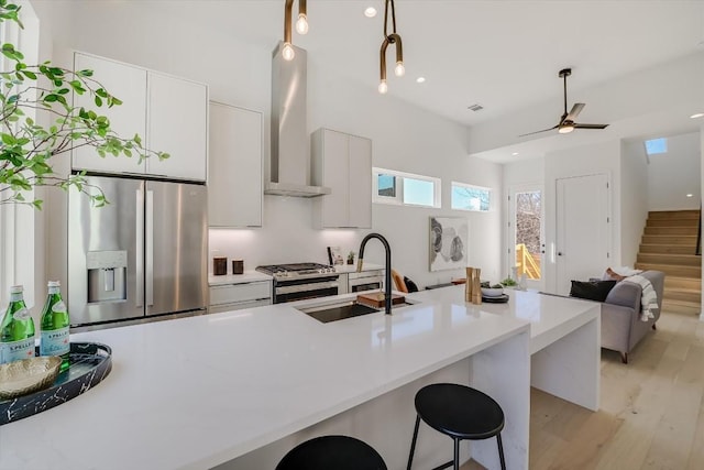 kitchen with stainless steel appliances, sink, a breakfast bar area, and white cabinets