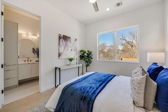 bedroom with ensuite bathroom, sink, ceiling fan, and light wood-type flooring