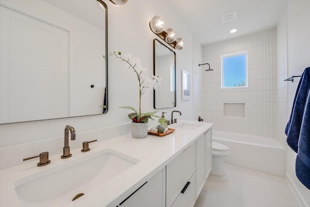 full bathroom featuring tiled shower / bath combo, vanity, tile patterned floors, and toilet