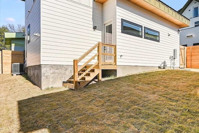 entrance to property featuring cooling unit and a yard