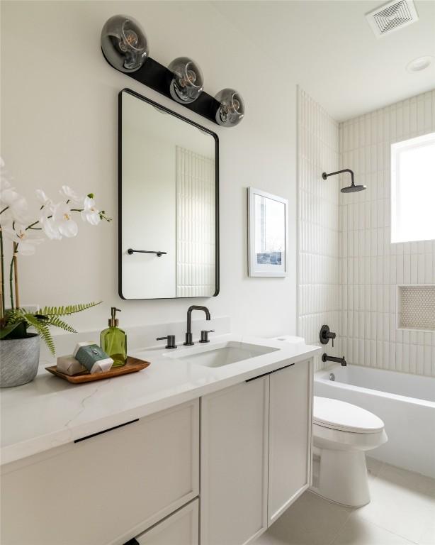 bathroom with tile patterned flooring, visible vents, washtub / shower combination, toilet, and vanity