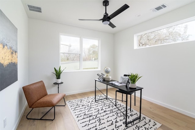 office featuring visible vents, baseboards, light wood-style floors, and ceiling fan