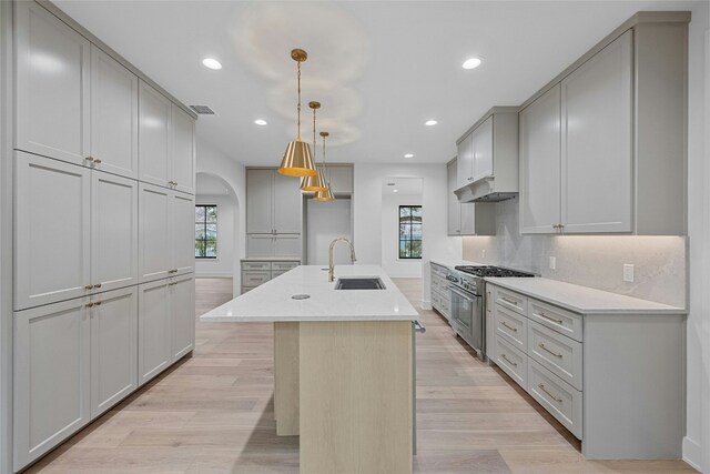 3008 W 50th St, Austin, TX 78731 - kitchen with stainless steel stove, arched walkways, healthy amount of natural light, gray cabinets, and recessed lighting