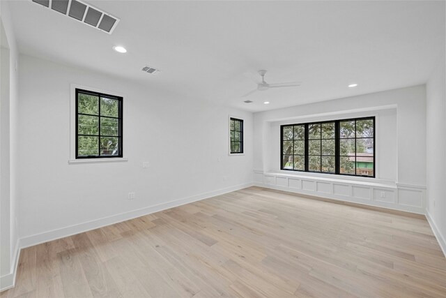 empty room with ceiling fan and light hardwood / wood-style floors