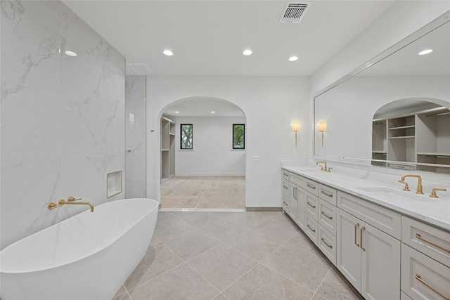 bathroom with vanity, a bathtub, and tile walls